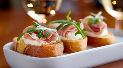 Obraz premium Delicious italian bruschetta with prosciutto, arugula and cream cheese enjoying a glass of wine