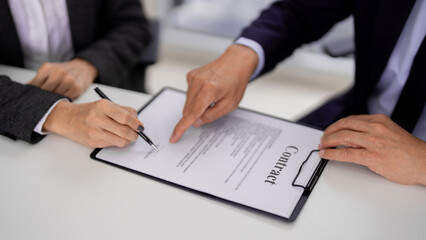 Adult Asian hands signing legal contract paperwork at a formal office meeting Business professionals finalize agreement document