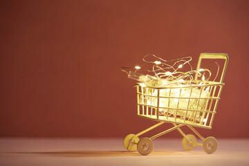 Shopping concept image with a shopping cart and Christmas led lights