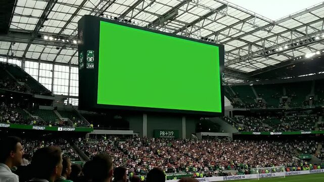 Chroma key green screen on a jumbotron in a packed stadium