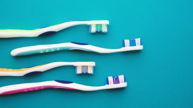 Four colorful toothbrushes arranged diagonally on a blue background.