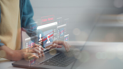 Person using a laptop with digital fake news alerts on screen. Concept of misinformation, social...