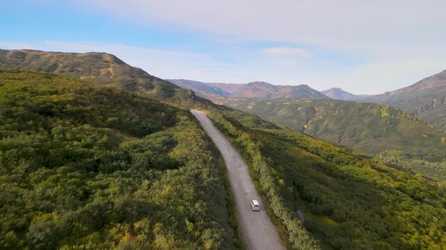 Autumn dirt road through Viluchinsky Pass, Kamchatka. Slopes with colorful vegetation. 825 m pass southwest of Petropavlovsk-Kamchatsky in South Kamchatka Nature Park.