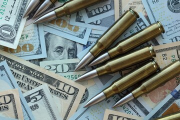 Yellow cartridges and bullets on dollar bills