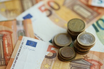 Stacks of euro cent coins lien on big amount of euro banknotes