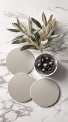 Light gray round coasters arranged on marble, with olive branch and olives