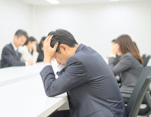 Fototapeta premium 頭を抱えてがっくりと落ち込む40代日本人男性