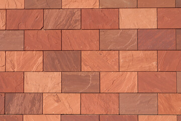 Obraz premium Abstract full-frame close-up of a wall of brown, terracotta-colored, and reddish rectangular bricks, showcasing their varied textures and hues in a precise, geometric pattern.