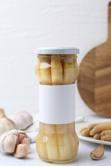 Pickled asparagus and garlic on white tiled table