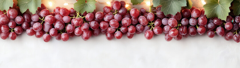 Fototapeta premium Red grape cluster with green leaves on white background, fresh and vibrant fruit arrangement glowing under soft light