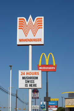 Giddings, TX, USA - Apr 9, 2025: Signs of various fast food restaurants, including Whataburger, McDonald's, and Taco Bell, are seen along U.S. Route 290 in Giddings, Texas.