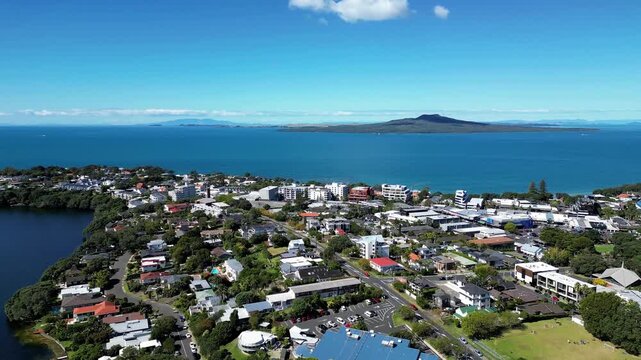 Drone scene of Takapuna with Lake Pupuke, houses, greenery and distant Rangitoto Island Auckland