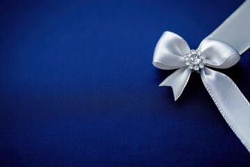 A close-up of a silver ribbon with a decorative bow and gem, set against a deep blue background, perfect for gifts or special occasions.