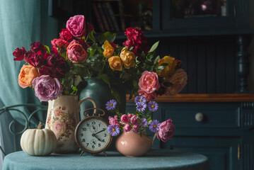 Bouquet of roses pumpkin and vintage clock in cozy cottage interior