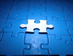 A single white puzzle piece in the center of a completed blue puzzle