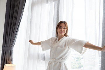Happy Caucasian woman with towel in bedroom  