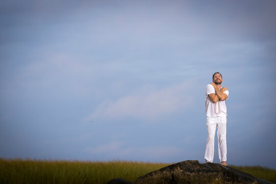 Man wearing white dancing in the beach on Cape Cod during the pi