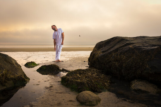 Man wearing white dancing in the beach on Cape Cod during the pi