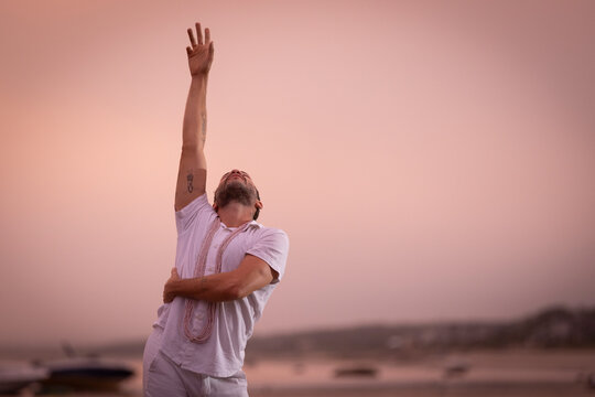 Man wearing white dancing in the beach on Cape Cod during the pi