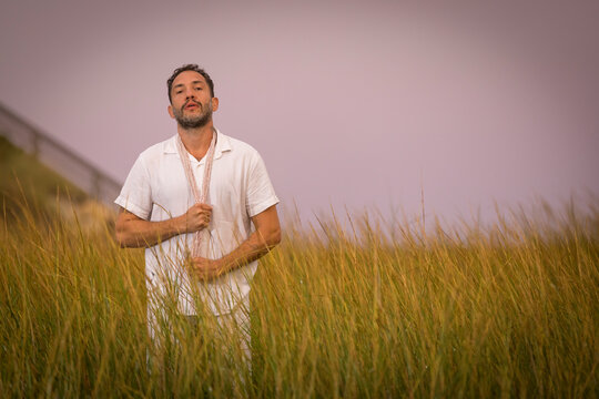 Man wearing white dancing in the beach on Cape Cod during the pi