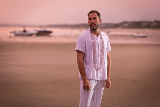 Man wearing white dancing in the beach on Cape Cod during the pi