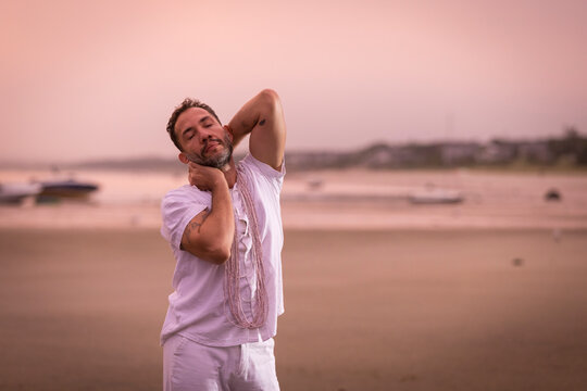 Man wearing white dancing in the beach on Cape Cod during the pi