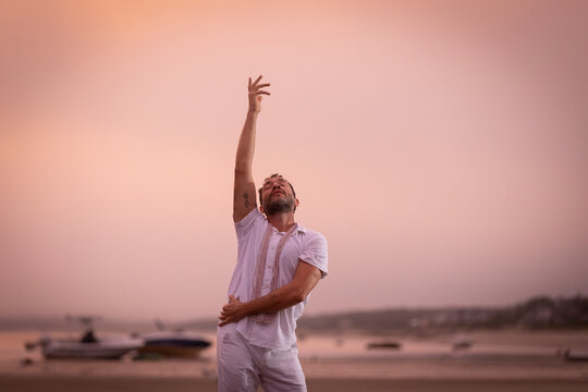 Man wearing white dancing in the beach on Cape Cod during the pi
