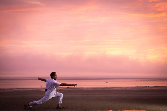 Man wearing white dancing in the beach on Cape Cod during the pi