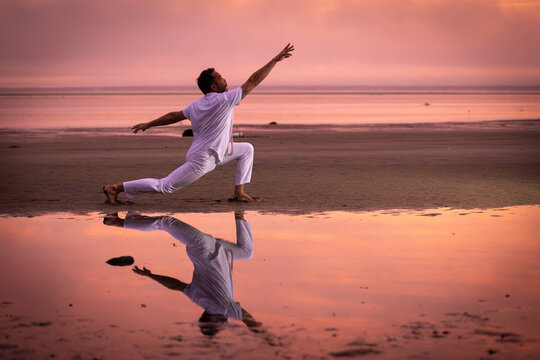 Man wearing white dancing in the beach on Cape Cod during the pi