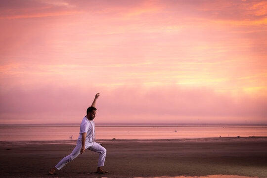 Man wearing white dancing in the beach on Cape Cod during the pi