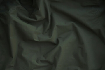 Texture of Dark green military uniform textile cloth with folds