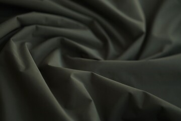 Texture of Dark green military uniform textile cloth with folds