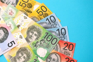 Few modern Australian dollar bills in different denominations lies on blue background