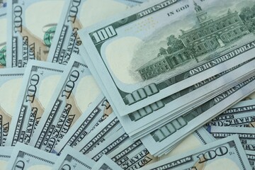 Many hundred dollar bills new banknotes in big pile under the natural light