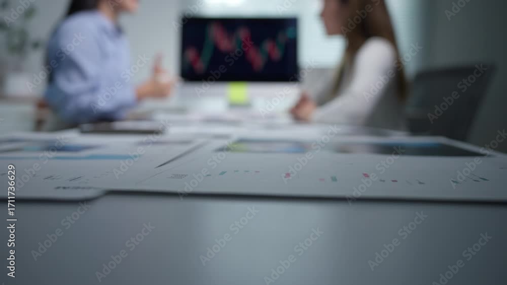 Poster financial paperwork arranged on office workspace while professional businesswomen analyzing data cha