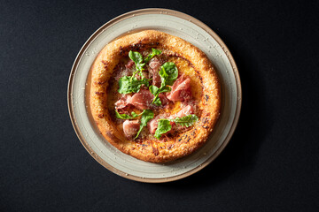 Artisan Pizza Delight: A delectable, wood-fired pizza, topped with fresh arugula and cured meats, rests on a rustic plate. A culinary journey.