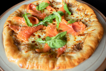 Smoked Salmon Pizza Delight: An overhead shot showcases a freshly baked pizza, adorned with delicate smoked salmon, complemented by fresh basil and a medley of tantalizing flavors.