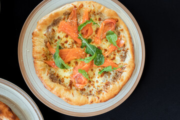 Gourmet Pizza Delight: A culinary masterpiece with smoked salmon, cheese, and fresh arugula toppings. showcasing the artistry of the food photography