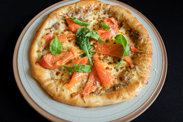 Salmon Pizza Culinary Art: This mouthwatering culinary masterpiece is a feast for the eyes. A close-up shot displays a freshly baked pizza, adorned with vibrant salmon fillets, fresh greens.
