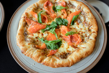 Gourmet Pizza with Salmon Delight: A close-up captures the artistry of a gourmet pizza, adorned...