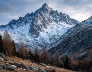Snowy mountain peak, autumnal forest at base