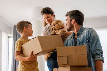 Smiling man and woman enjoy unpacking with child moving to own home. Rent, mortgage concept