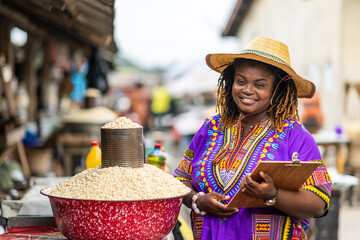 Portrait of Local African traditional woman entrepreneur, small business owner, SME, holding a...