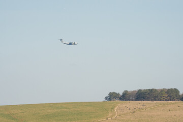 RAF Airbus C.1 A400M Atlas military transport aircraft in flight on a low-level cargo drop run, blue sky