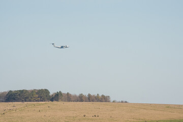 RAF Airbus C.1 A400M Atlas military transport aircraft in flight on a low-level cargo drop run, blue sky