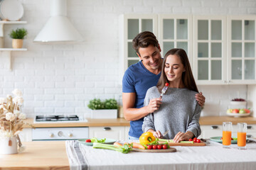 Young man and woman are jointly preparing wholesome vegetable-based meals in the kitchen, enjoying quality time together and focusing on balanced eating