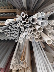 PVC pipes stacked in warehouses, piles of pipes of various sizes in building materials stores.