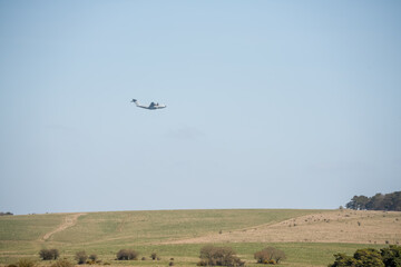RAF Airbus C.1 A400M Atlas military transport aircraft in flight on a low-level cargo drop run, blue sky