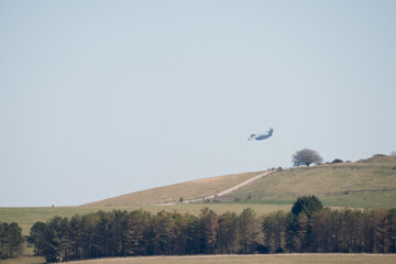RAF Airbus C.1 A400M Atlas military transport aircraft in flight on a low-level cargo drop run, blue sky