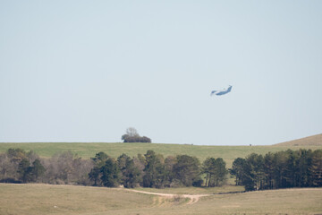 RAF Airbus C.1 A400M Atlas military transport aircraft in flight on a low-level cargo drop run, blue sky